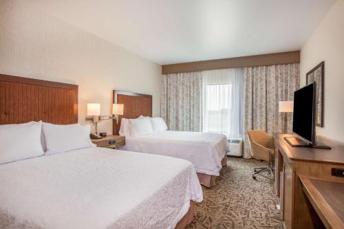 a hotel room with two beds and a flat screen tv at Hampton Inn & Suites Pasco/Tri-Cities, WA in West Pasco