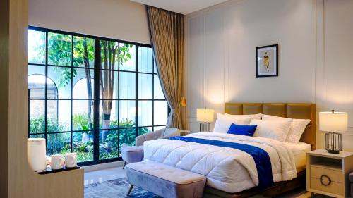 a bedroom with a bed and a large window at Bincarung House Bogor in Bogor