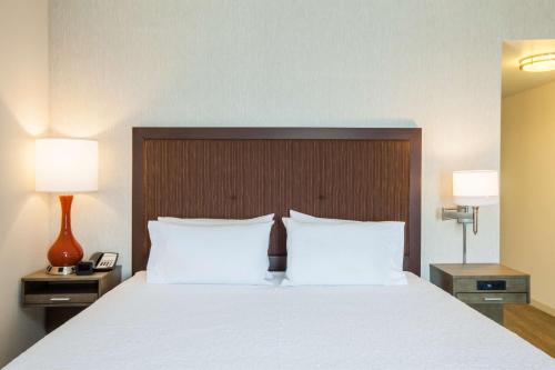 a bedroom with a bed with white sheets and two lamps at Hampton Inn & Suites Pasco/Tri-Cities, WA in West Pasco