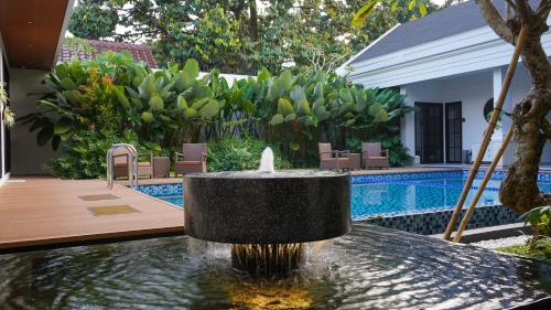 a fountain in the middle of a swimming pool at Bincarung House Bogor in Bogor