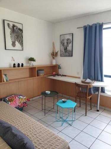 a living room with a bed and a table and chairs at Studio Bourran + parking in Rodez