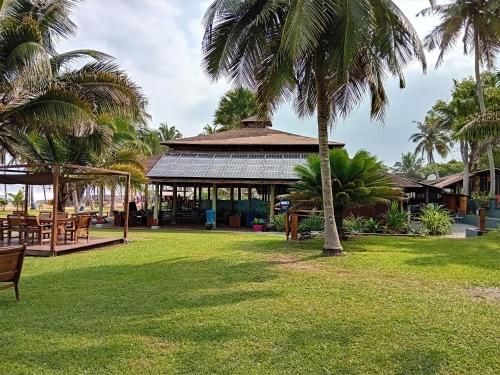 a gazebo in a park with palm trees at Ko-Sa Beach Resort Ltd in Ampeni