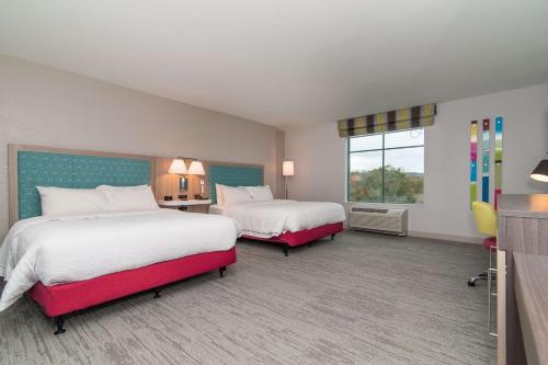 a hotel room with two beds and a window at Hampton Inn Norwich in Norwich