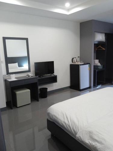 a bedroom with a bed and a desk and a mirror at D Night Suite Hotel in Bangkok