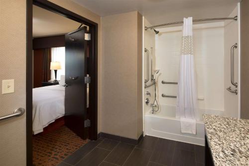 a bathroom with a shower and a bed and a tub at Hampton Inn Lewiston-Auburn in Lewiston