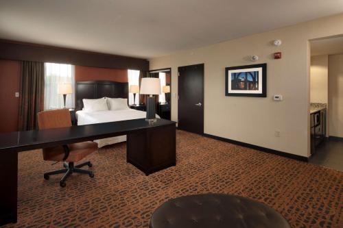 a hotel room with a bed and a desk at Hampton Inn Lewiston-Auburn in Lewiston