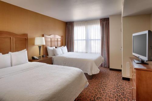 a hotel room with two beds and a flat screen tv at Hampton Inn & Suites Orem/Provo in Orem