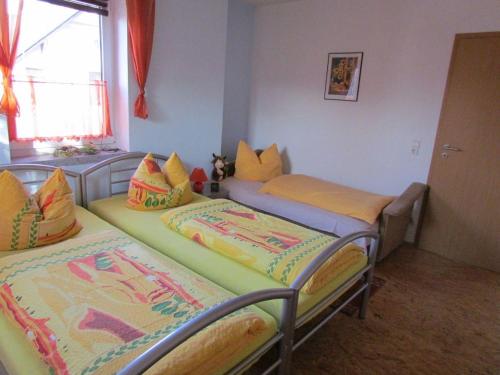2 camas individuales en una habitación con ventana en Ferienwohnung-Heidi, en Kirschau