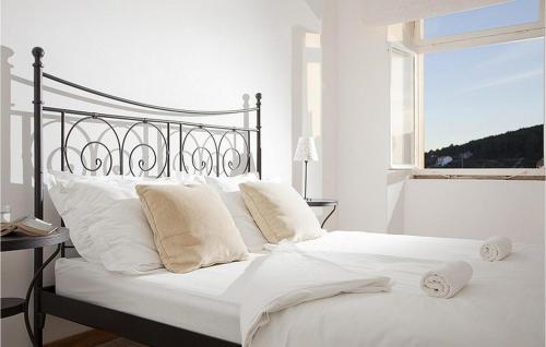 a white bed with white pillows and a window at Villa Mar in Lumbarda