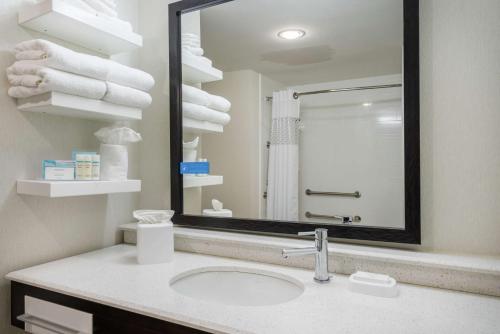 uma casa de banho com lavatório, espelho e toalhas em Hampton Inn by Hilton Oxford, ME em Oxford