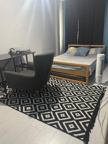 ein Schlafzimmer mit einem Bett, einem Stuhl und einem Teppich in der Unterkunft Deluxe Two bedroom apartment in nışantaşı in Istanbul
