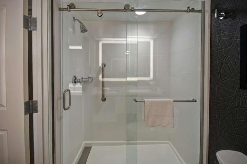a bathroom with a shower with a glass door at DoubleTree by Hilton Deadwood at Cadillac Jack's in Deadwood