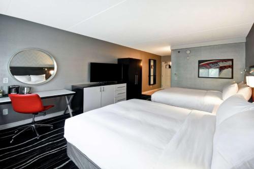 a hotel room with two beds and a desk at DoubleTree by Hilton Deadwood at Cadillac Jack's in Deadwood