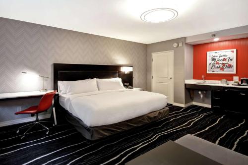 a bedroom with a large bed and a desk and a chair at DoubleTree by Hilton Deadwood at Cadillac Jack's in Deadwood