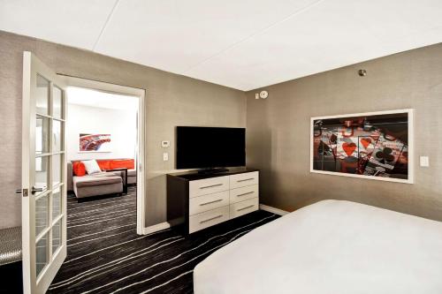 a bedroom with a bed and a flat screen tv at DoubleTree by Hilton Deadwood at Cadillac Jack's in Deadwood
