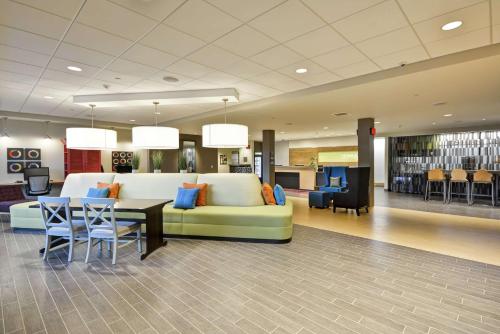 a lobby with a couch and a table and chairs at Home2 Suites By Hilton Rapid City in Rapid City