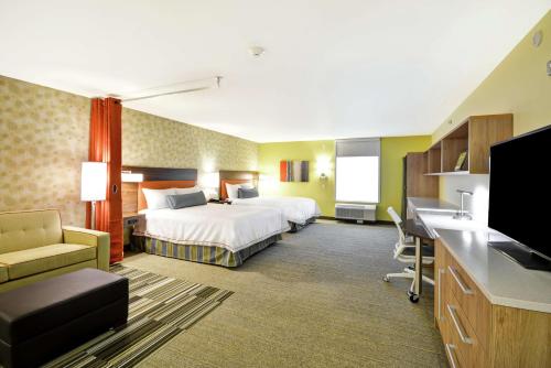 Habitación de hotel con cama y escritorio en Home2 Suites By Hilton Rapid City en Rapid City