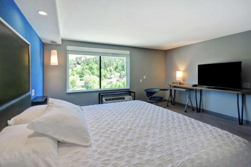um quarto com uma cama grande e uma televisão de ecrã plano em Tru By Hilton Deadwood em Deadwood