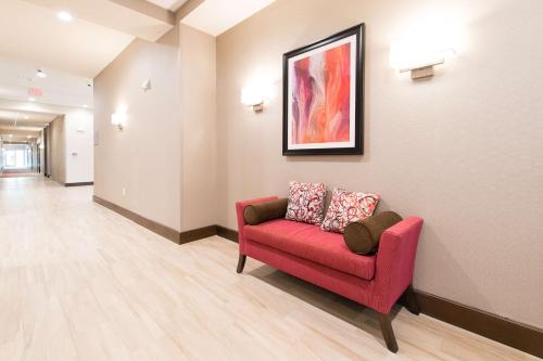 a waiting room with a red couch and a painting at Hampton Inn & Suites Walterboro in Walterboro