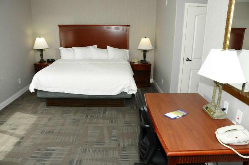 a hotel room with a bed and a desk with a phone at Hampton Inn & Suites Redding in Redding