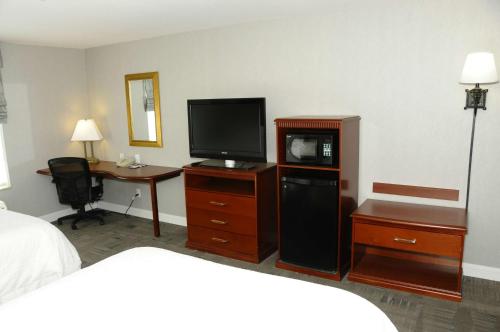 Habitación de hotel con cama, TV y escritorio. en Hampton Inn & Suites Redding, en Redding