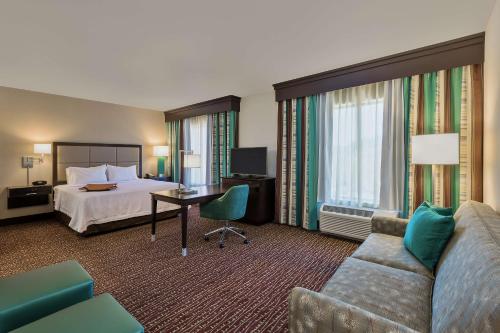 a hotel room with a bed and a couch at Hampton Inn & Suites Bend in Bend