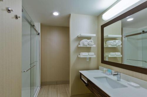 a bathroom with a sink and a shower and a mirror at Hampton Inn & Suites Bend in Bend