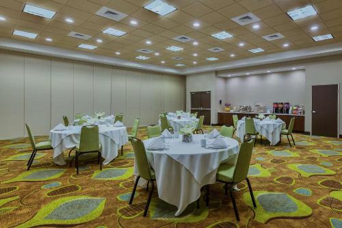 a banquet room with tables and chairs with white tablecloths at Hampton Inn & Suites Bend in Bend