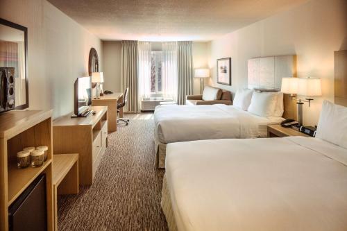 a hotel room with two beds and a television at DoubleTree by Hilton Bend in Bend