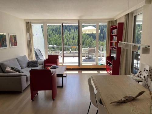 una sala de estar con un sofá y una mesa en Tulai D74, en Scuol