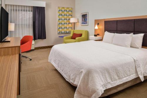 a hotel room with a bed and a television at Hampton Inn Raleigh Clayton I-40 Garner in Garner