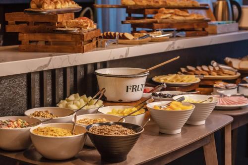 a buffet with bowls of food on a table at Mulen Hotel Tandil in Tandil