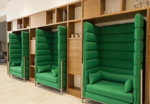a row of green chairs in a room at Embassy Suites by Hilton Raleigh Crabtree in Raleigh