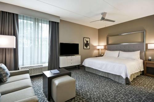 pokój hotelowy z łóżkiem i telewizorem w obiekcie Homewood Suites by Hilton Raleigh Cary I-40 w mieście Cary