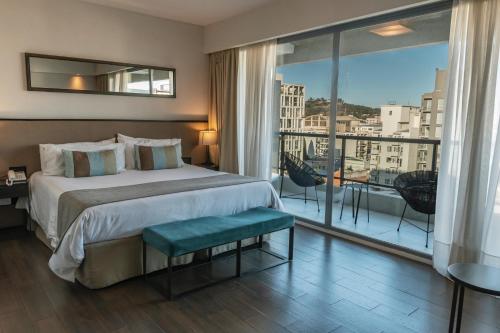 a hotel room with a bed and a large window at Mulen Hotel Tandil in Tandil