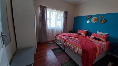 a bedroom with a bed and a blue wall at Huisie Langs Die See in Swakopmund