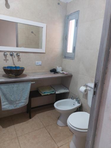 a bathroom with a sink and a toilet and a mirror at Casa country al lado de la montaña! in Santa Rosa