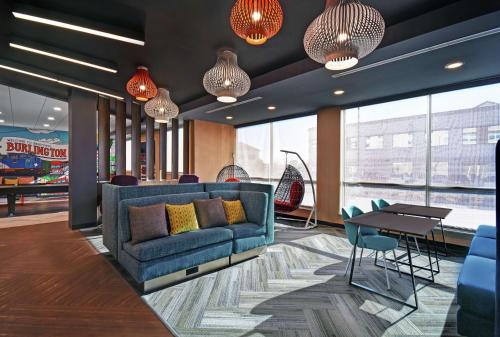 a lobby with a blue couch and a table at Tru By Hilton Burlington in Burlington