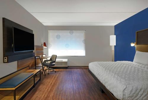 a hotel room with a bed and a flat screen tv at Tru By Hilton Burlington in Burlington
