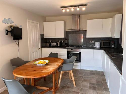 a kitchen with a wooden table with chairs and a tableasteryasteryasteryasteryastery at 2 bedroom house with lovely garden and views in Brighton & Hove