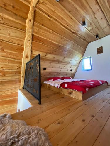 a bedroom in a log cabin with a bed in it at Cabana JagerBerg Rosenau in Râşnov