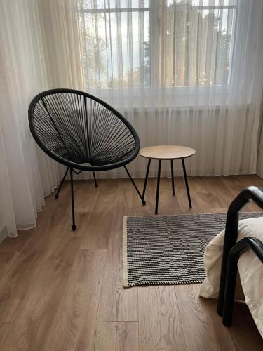 a room with a chair and a table and a window at Black&White Apartment in Uzwil