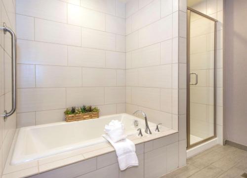 卡瑞的住宿－羅利卡瑞希爾頓花園酒店，白色的浴室设有浴缸和淋浴。