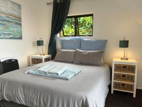 Una cama con dos lámparas y toallas. en Big Fish Seaside Cottage, Sleeps 10 Guests in 5 Bedrooms, en Port Edward