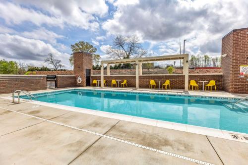 a swimming pool with chairs and a gazebo at Home2 Suites by Hilton Raleigh West Lenovo Center in Raleigh