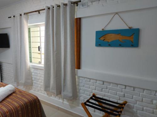 a bedroom with a dolphin picture on the wall at Pousada Ninhal das Garças in Ilha Comprida