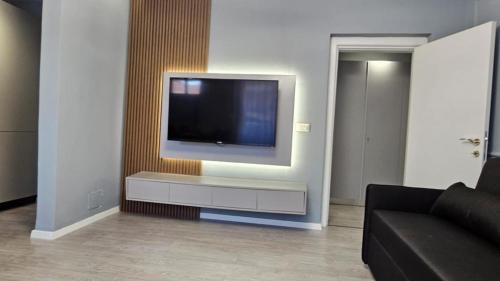 sala de estar con TV de pantalla plana en la pared en City Center Apartment, en Tirana