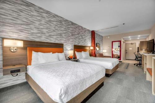 a hotel room with two beds and a kitchen at Home2 Suites by Hilton Raleigh West Lenovo Center in Raleigh