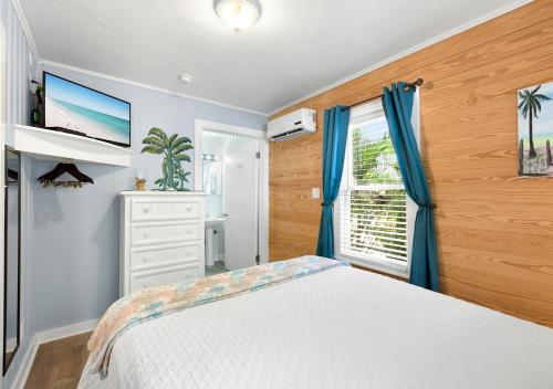 a bedroom with a white bed and a window at The Grand Guesthouse in Key West