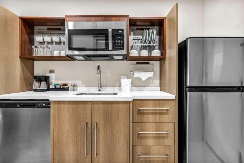 a kitchen with a sink and a microwave and a refrigerator at Home2 Suites by Hilton Raleigh West Lenovo Center in Raleigh